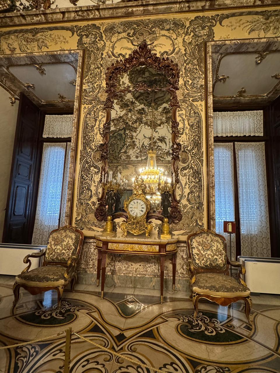 Opulent palace interior — gold mirrors and clocks